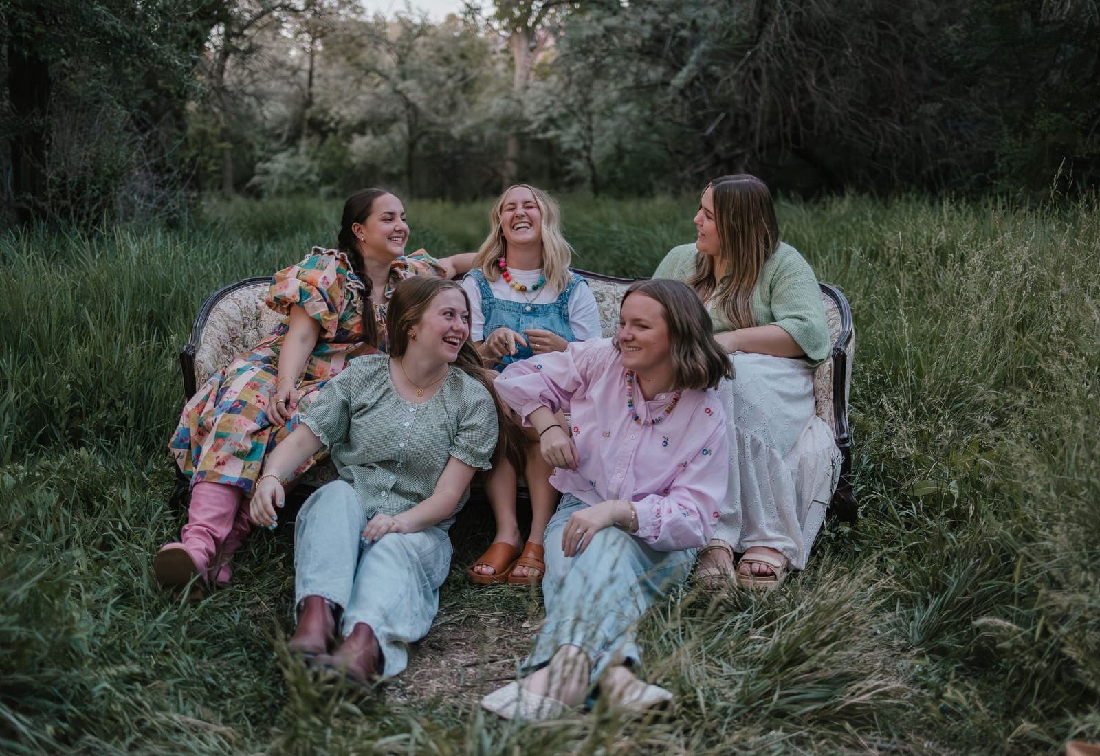 The team laughing together on a vintage couch