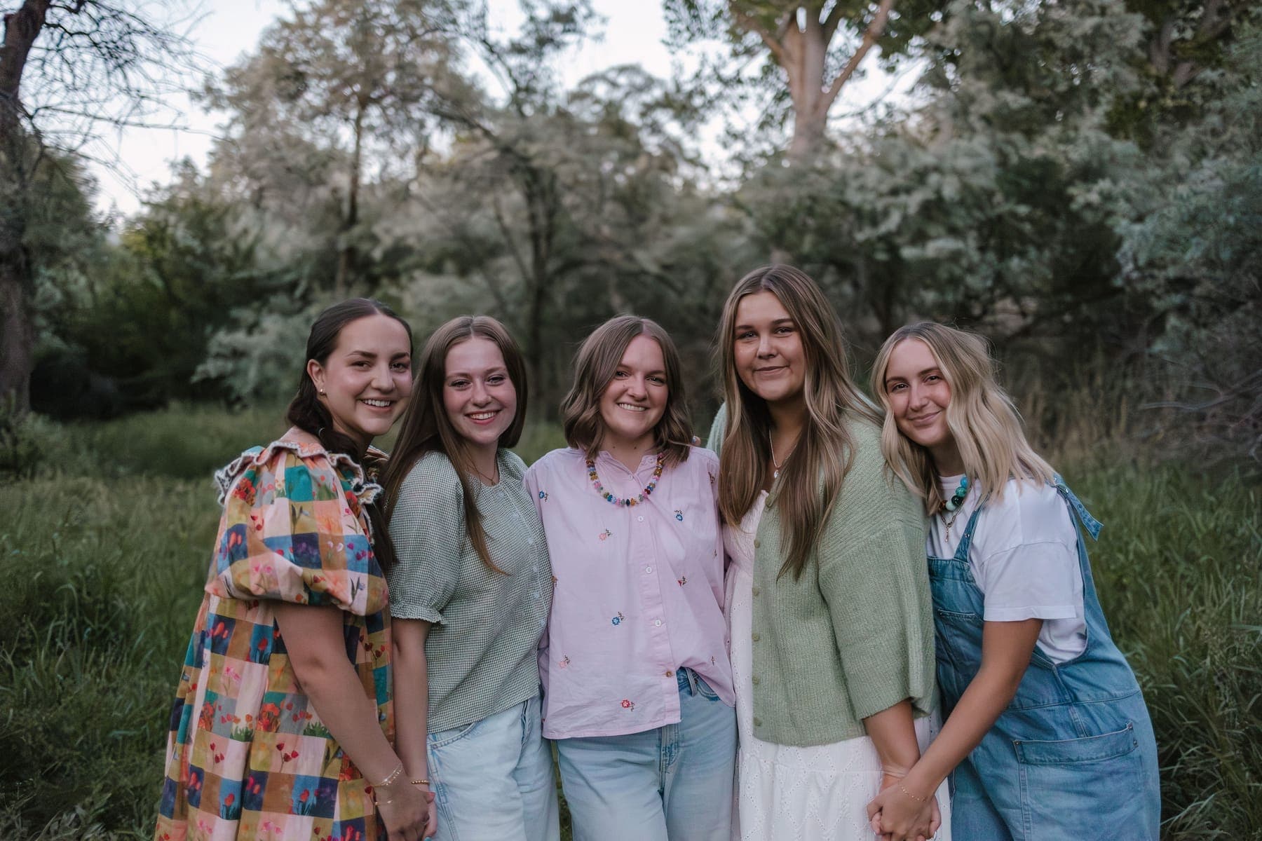 The five members of the Embrace Media team standing together in a green field